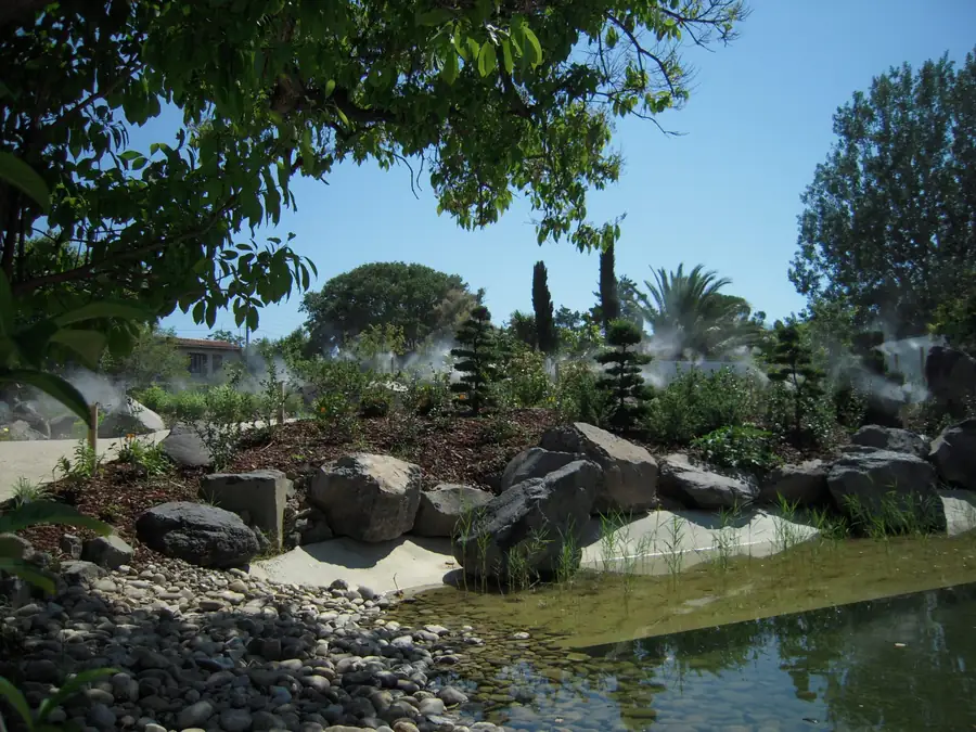 Jardin paysager parcouru de buses basses diffusant la brume